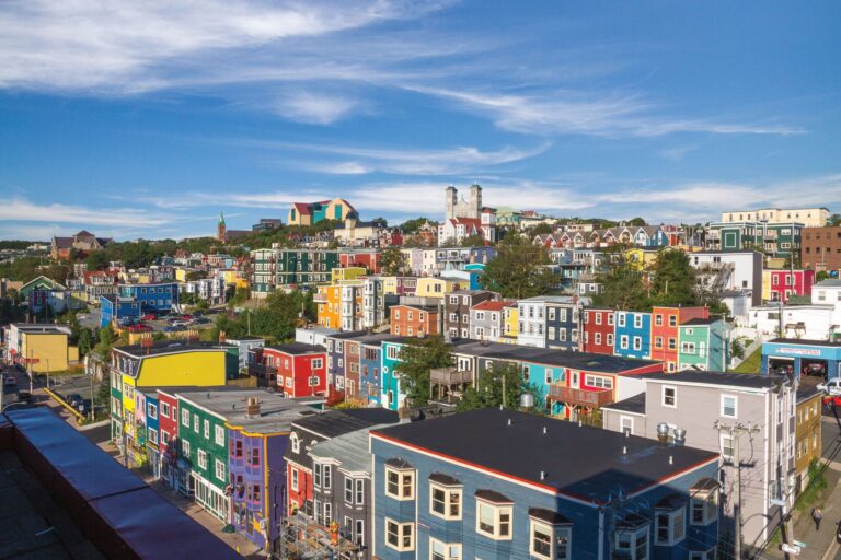 Colorful row houses in downtown St. John’s, Newfoundland, under a bright blue sky.